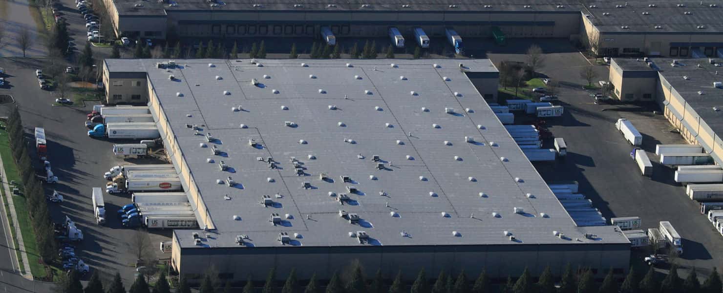 Aerial view of a low slope roof on a large warehouse.